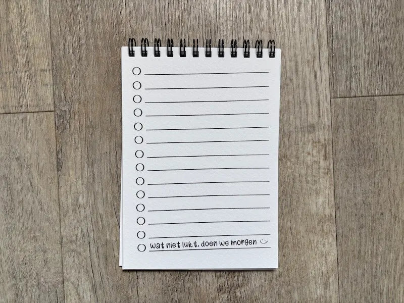 Ingepakt notitieboekje voor de meester met kaartje en lint, klaar om cadeau te geven
